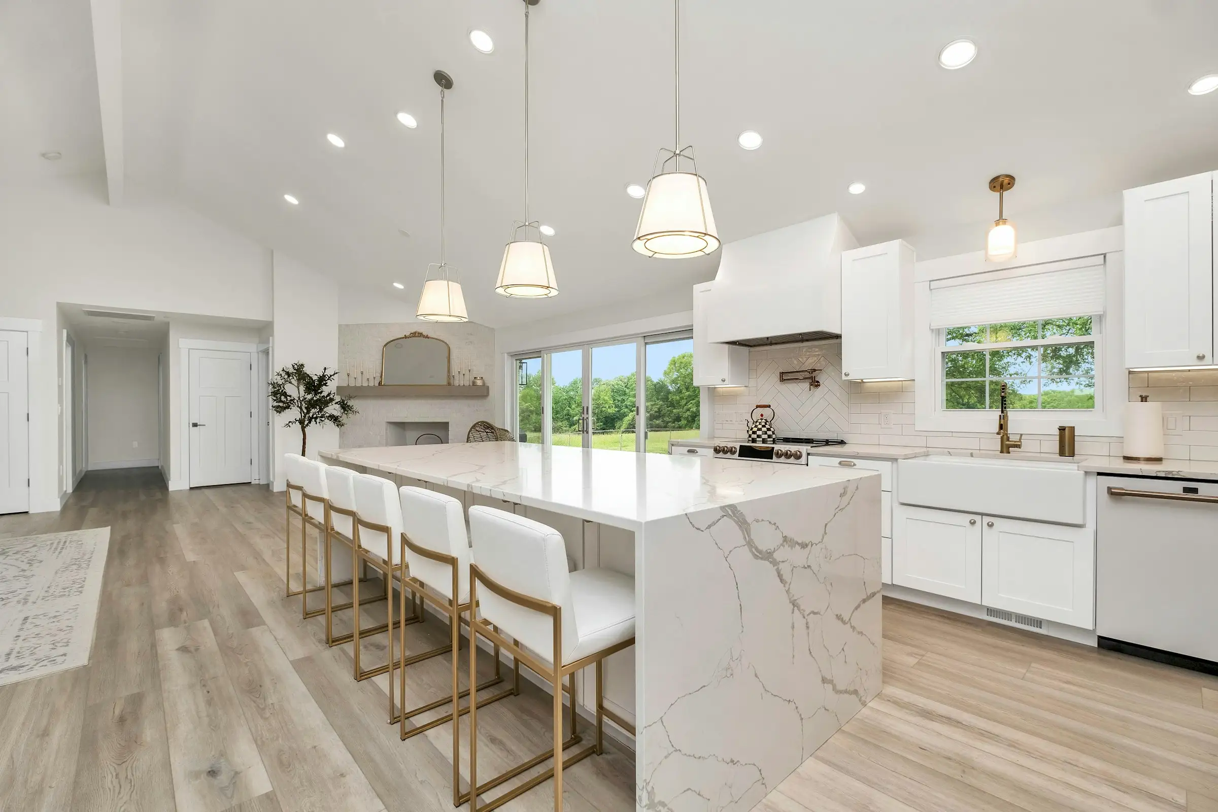 Cocina reformada, luminosa, con isla de mármol y armarios blancos
