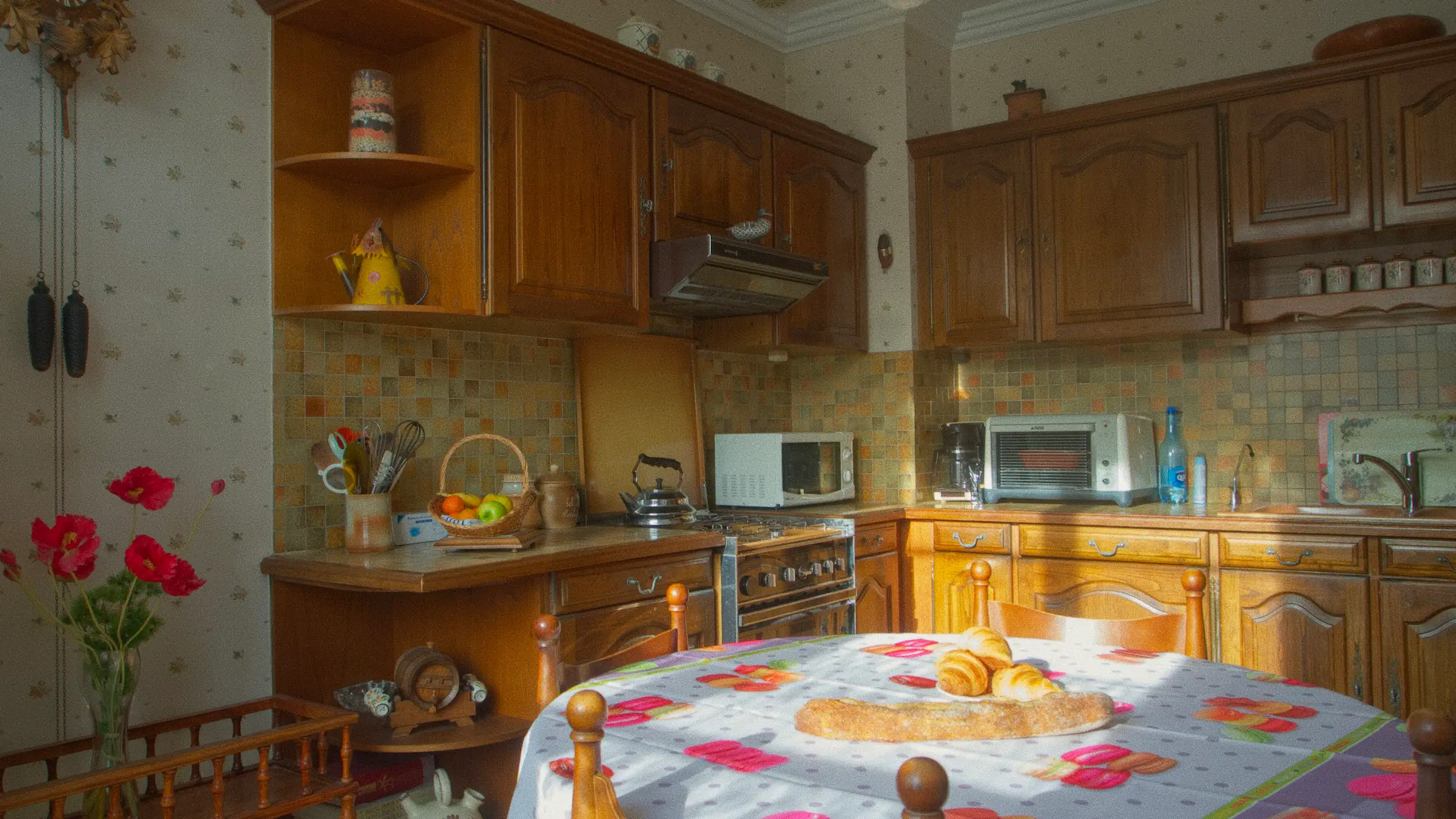 Cocina antigua con armarios de madera oscura y mesa con mantel